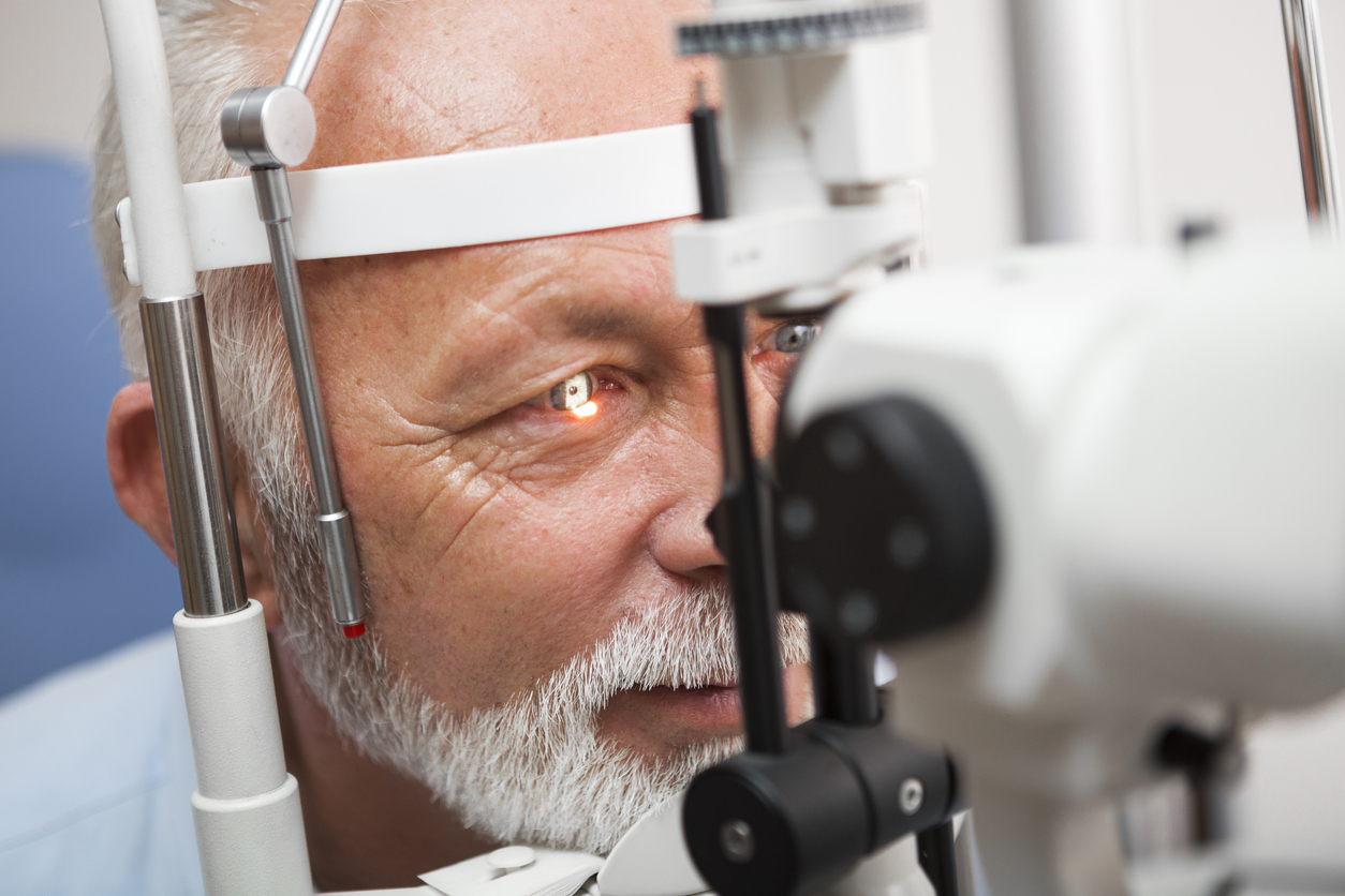 Senior man doing eye test with,close up